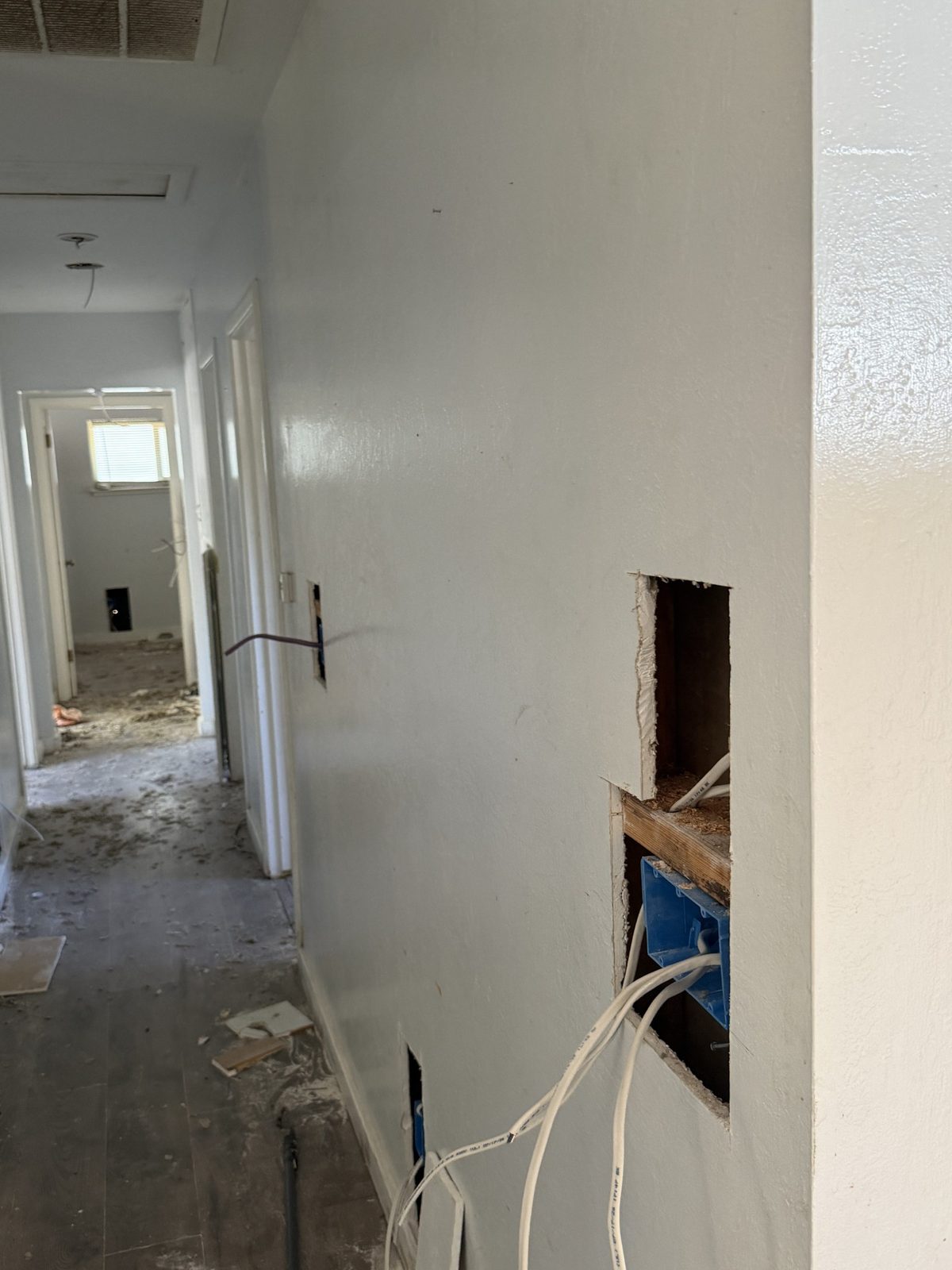 Interior hallway with selective wall openings during electrical rewiring work