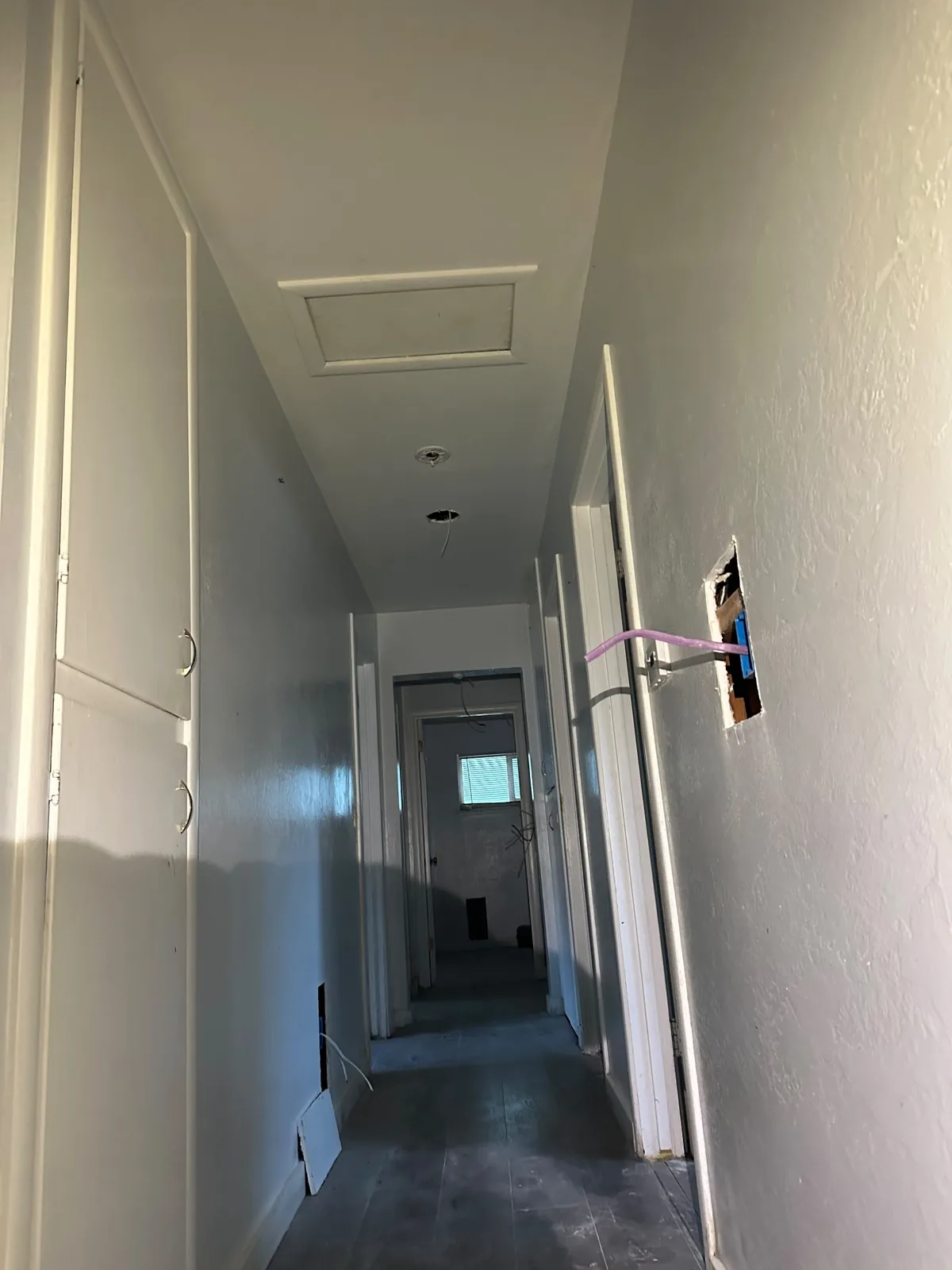 New wiring routed through hallway wall openings during whole-house rewiring in Davis